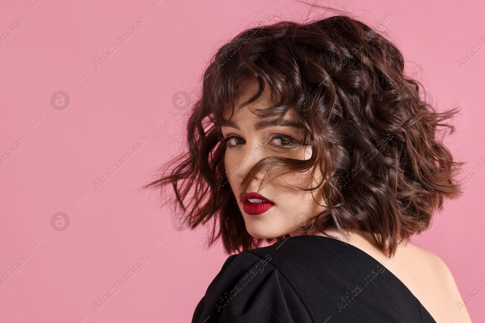 Photo of Portrait of beautiful young woman with wavy hairstyle on pink background. Space for text