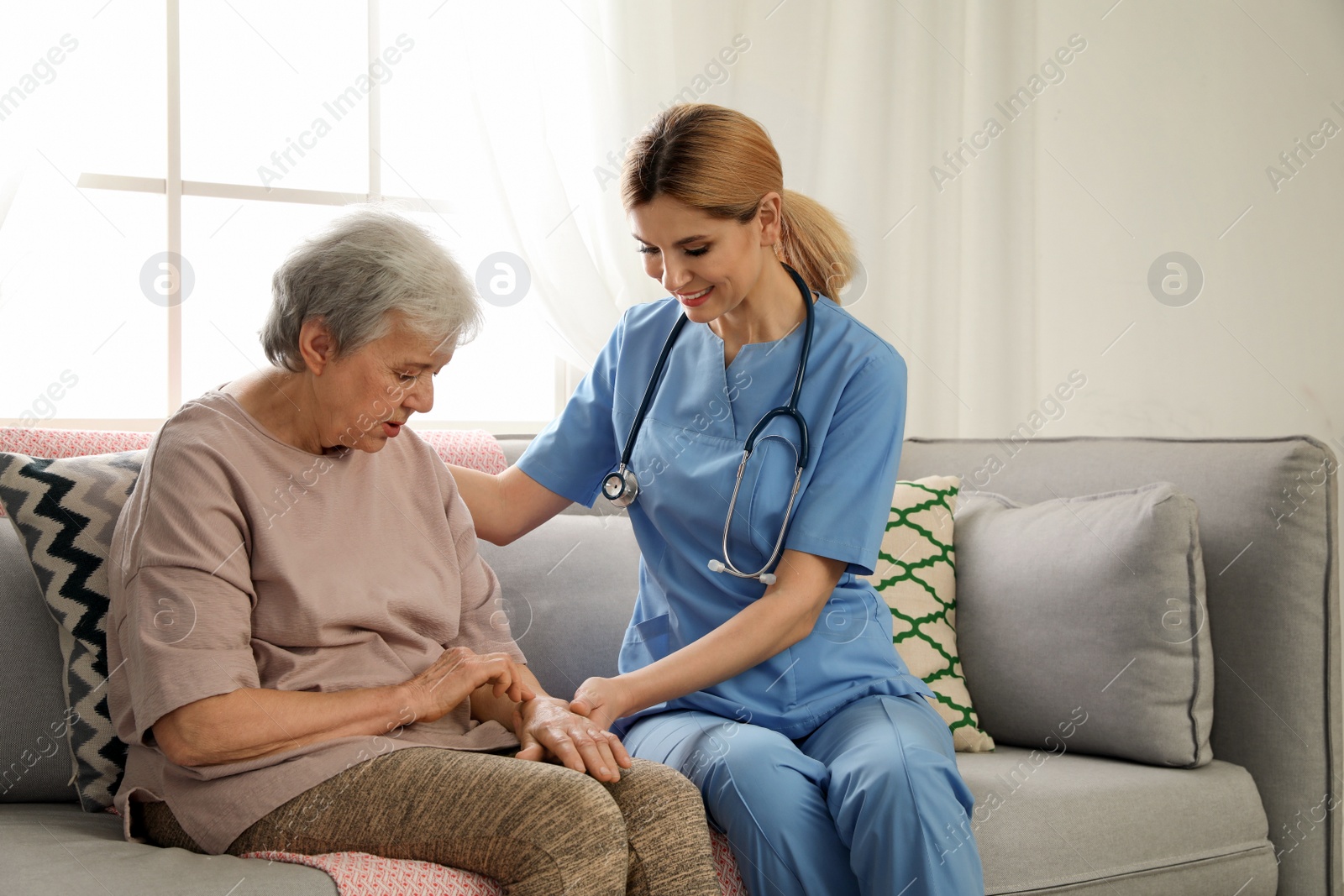 Photo of Nurse with elderly woman indoors. Assisting senior people