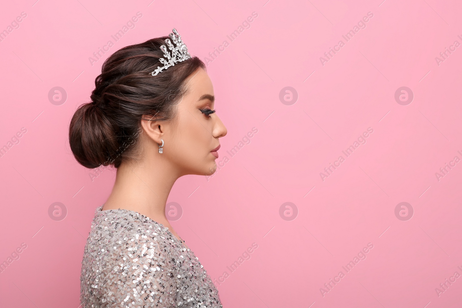 Photo of Beautiful young woman wearing luxurious tiara on pink background, space for text