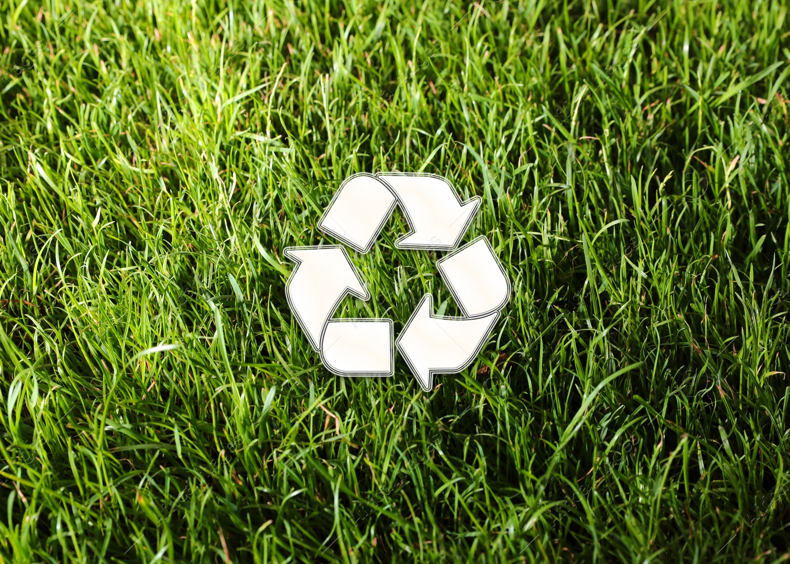 Image of Green grass and illustration of recycling symbol