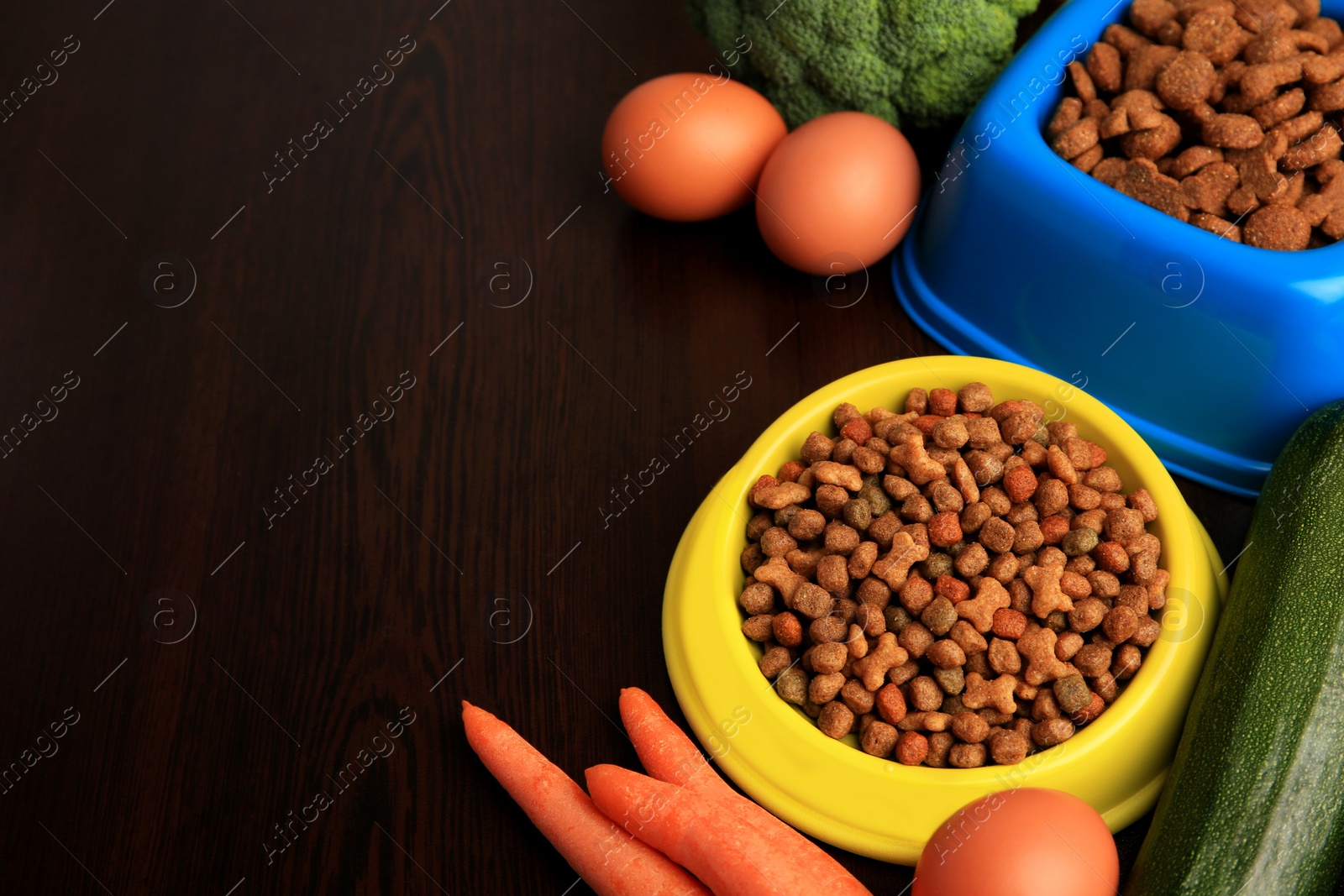 Photo of Dry pet food and products on wooden background. Space for text