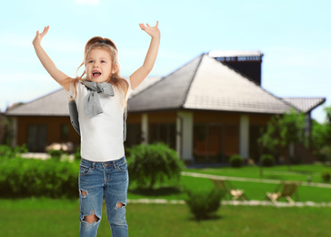 Image of Happy little girl jumping near house, space for text. School holidays