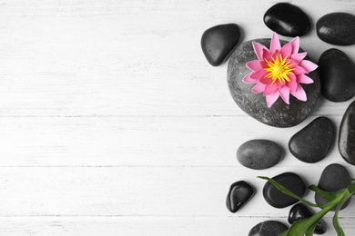 Stones, bamboo, lotus flower and space for text on white wooden background, flat lay. Zen lifestyle