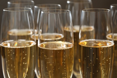 Many glasses of champagne as background, closeup view