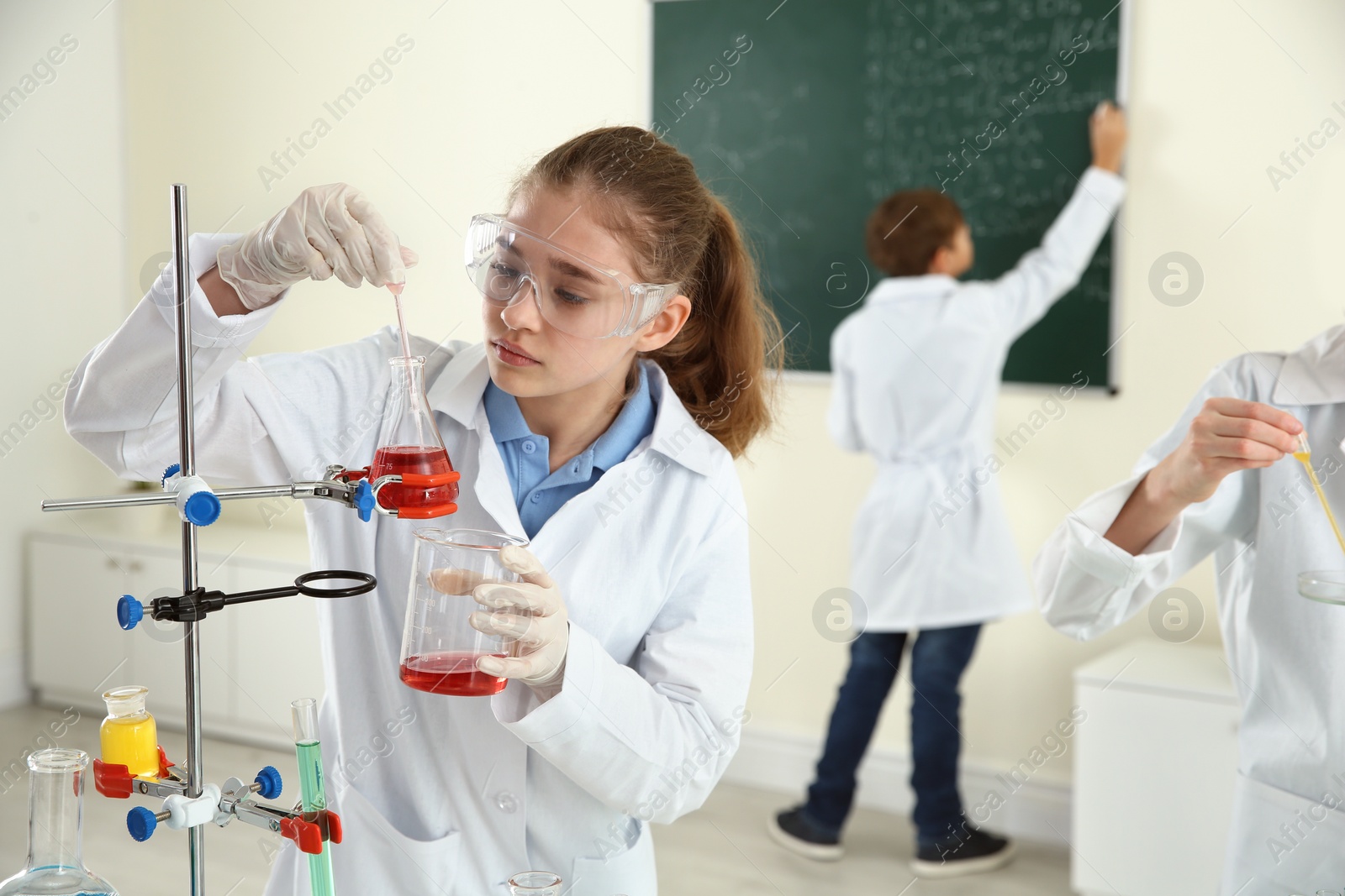 Photo of Smart pupils making experiment in chemistry class