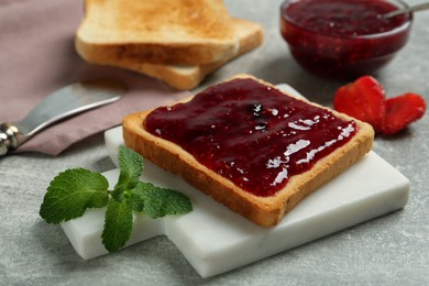 Delicious toast with jam and mint on light grey table, closeup