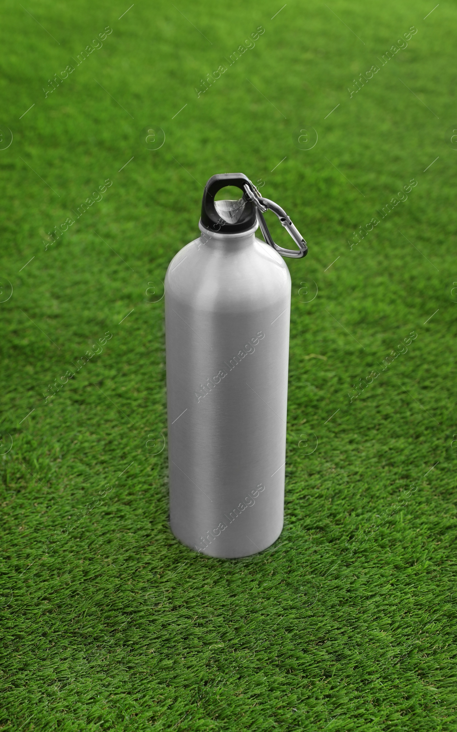 Photo of Bottle of water on artificial grass. Fitness equipment