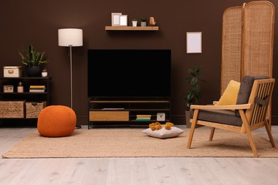 Photo of Modern TV on cabinet, stylish furniture and decorative elements in room. Interior design