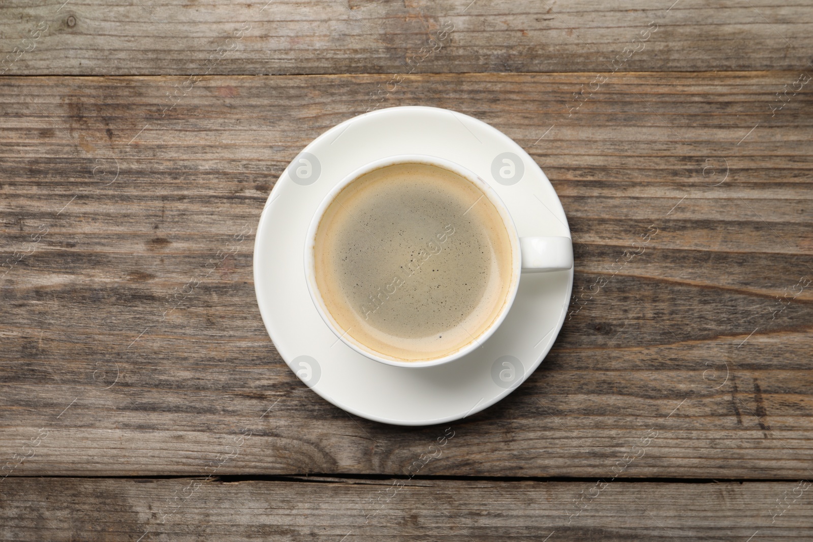 Photo of Aromatic coffee in cup on wooden table, top view