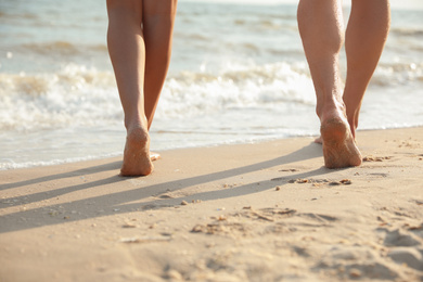 Photo of Young couple walking together on beach, closeup