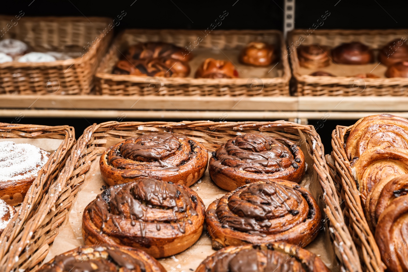 Photo of Wicker trays with different sweet buns in bakery