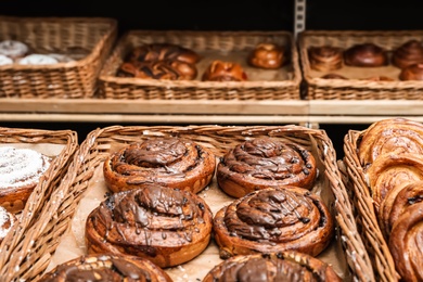 Photo of Wicker trays with different sweet buns in bakery