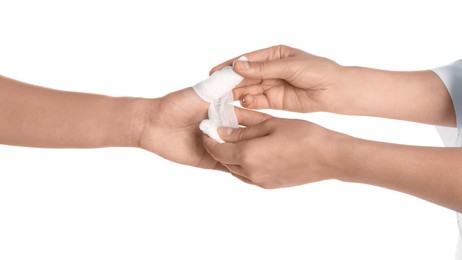 Photo of Doctor applying bandage onto patient's thumb on white background, closeup