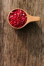 Cup with tasty ripe lingonberries on wooden surface, top view. Space for text