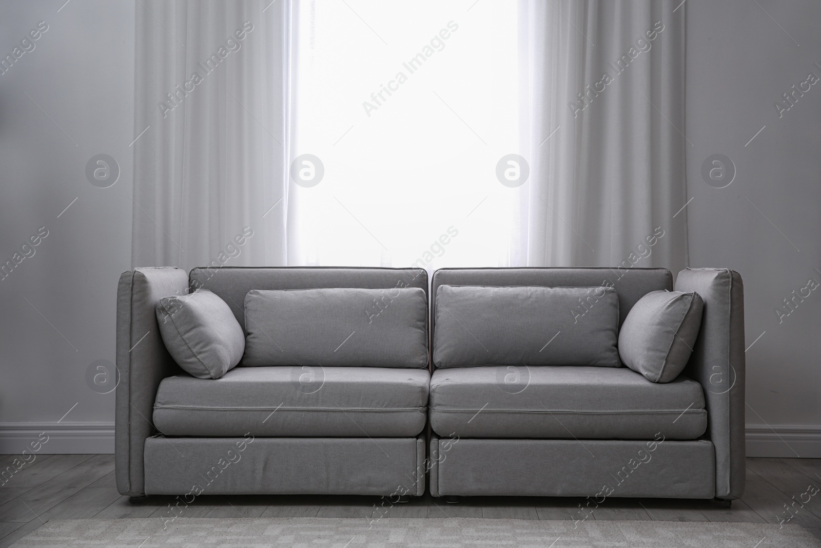 Photo of Simple living room interior with comfortable sofa near window. Space for text