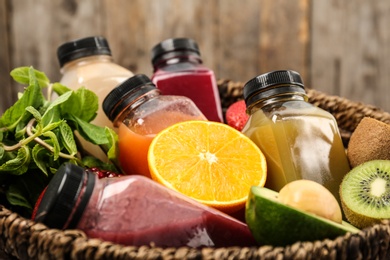 Basket with healthy detox smoothies and ingredients, closeup