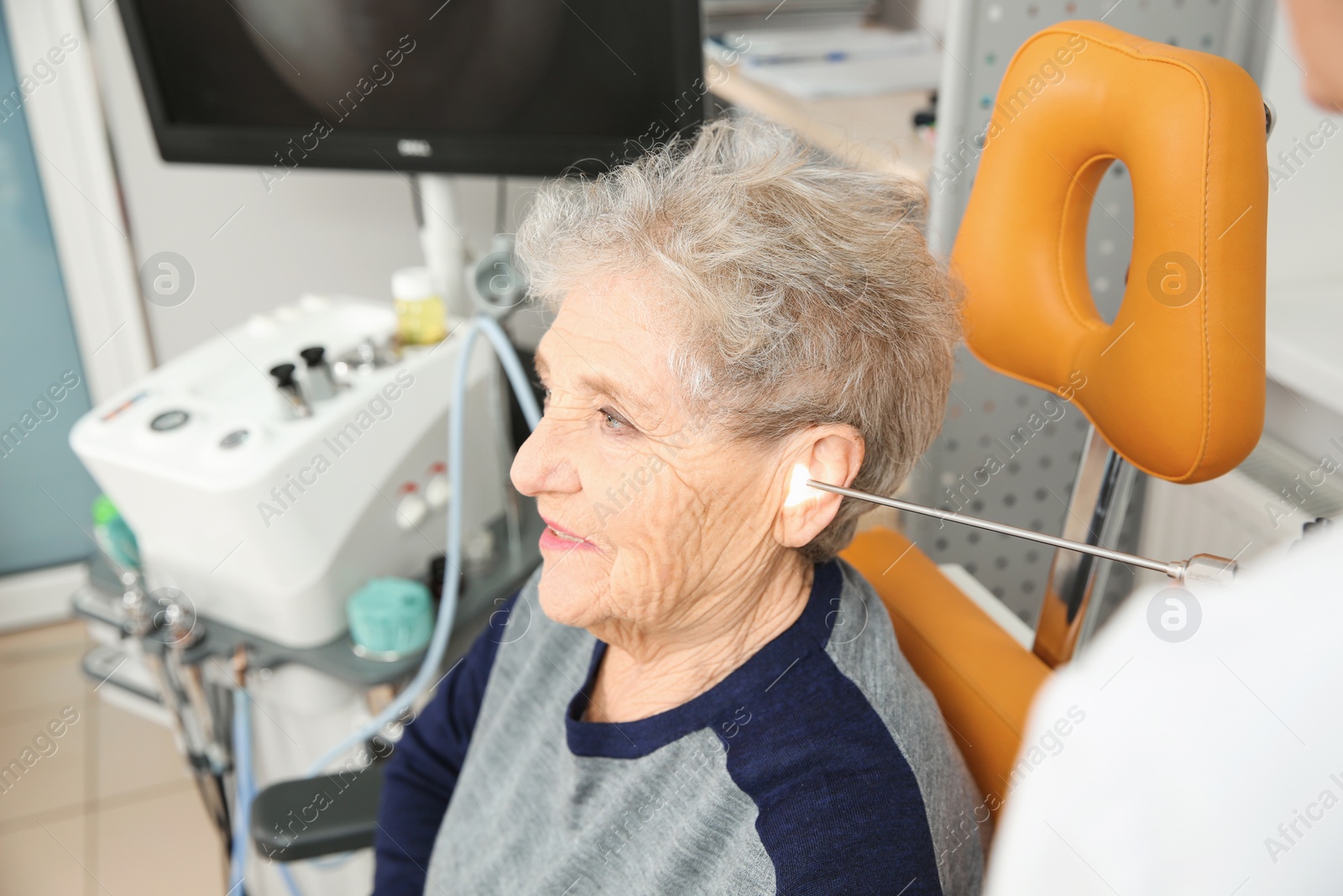 Photo of Professional otolaryngologist examining senior woman with endoscope in clinic. Hearing disorder