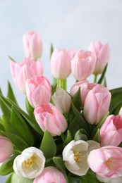 Photo of Beautiful bouquet of tulips against light background, closeup