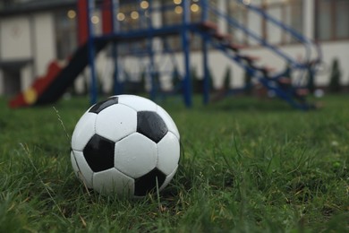 Photo of Wet leather soccer ball on grass outdoors, space for text