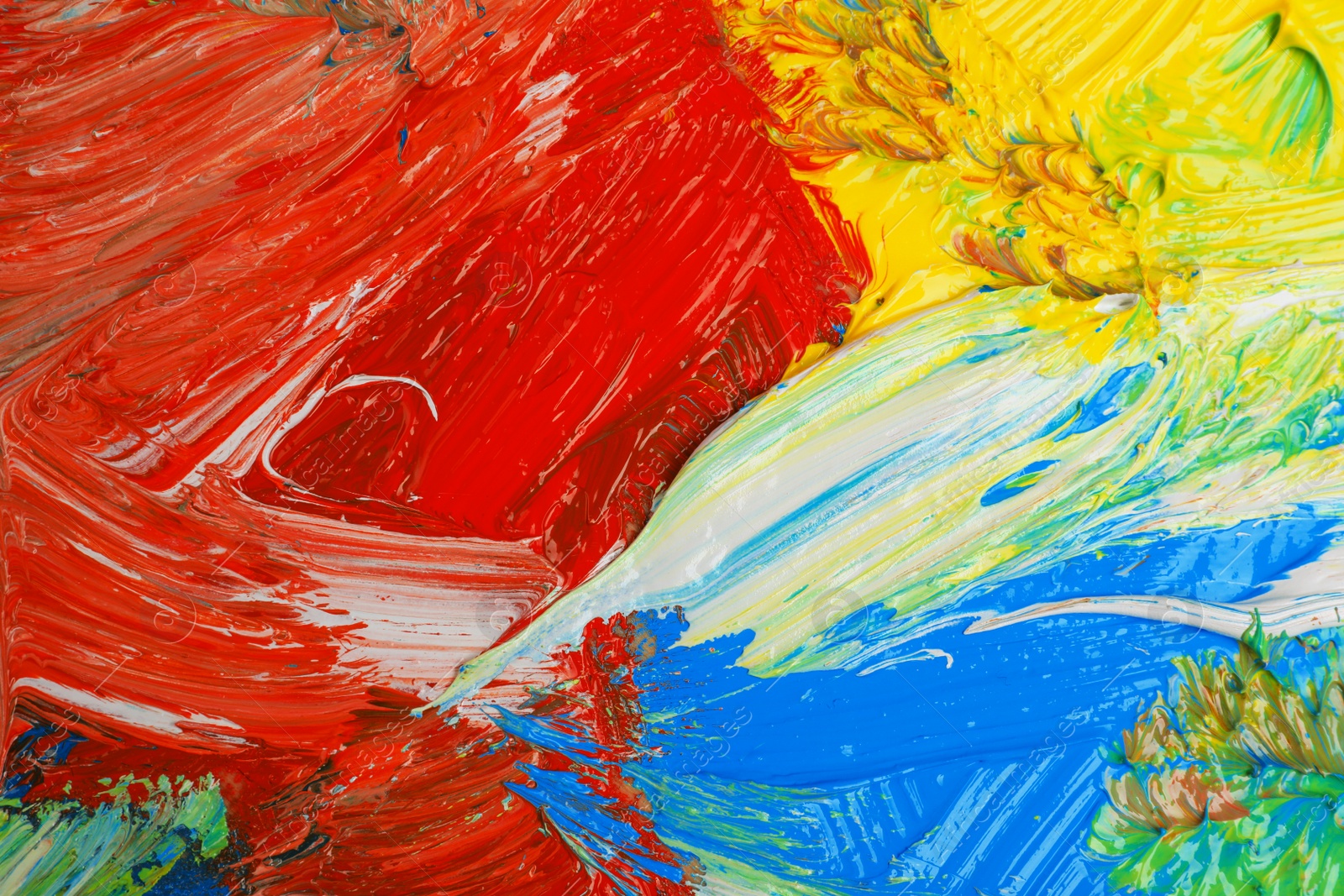 Photo of Closeup view of artist's palette with mixed bright paints as background