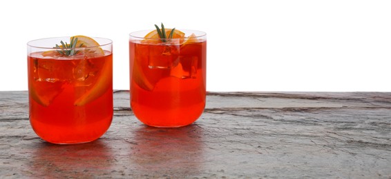 Photo of Aperol spritz cocktail, orange slices and rosemary in glasses on grey textured table against white background