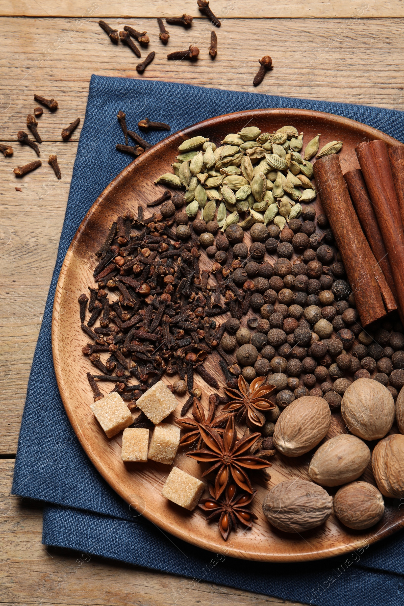 Photo of Different spices and nuts on wooden table, top view