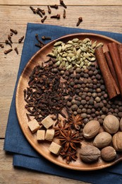 Different spices and nuts on wooden table, top view