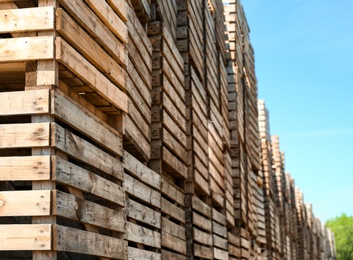 Pile of empty wooden crates outdoors on sunny day. Space for text