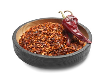 Plate with crushed chili pepper and pods on white background