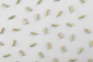 Photo of Many vitamin capsules on white background, flat lay