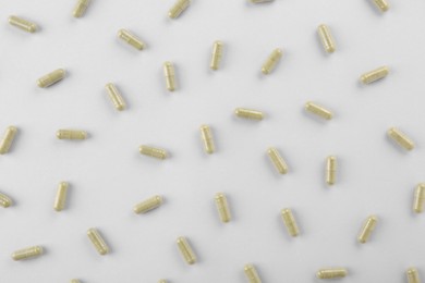 Many vitamin capsules on white background, flat lay