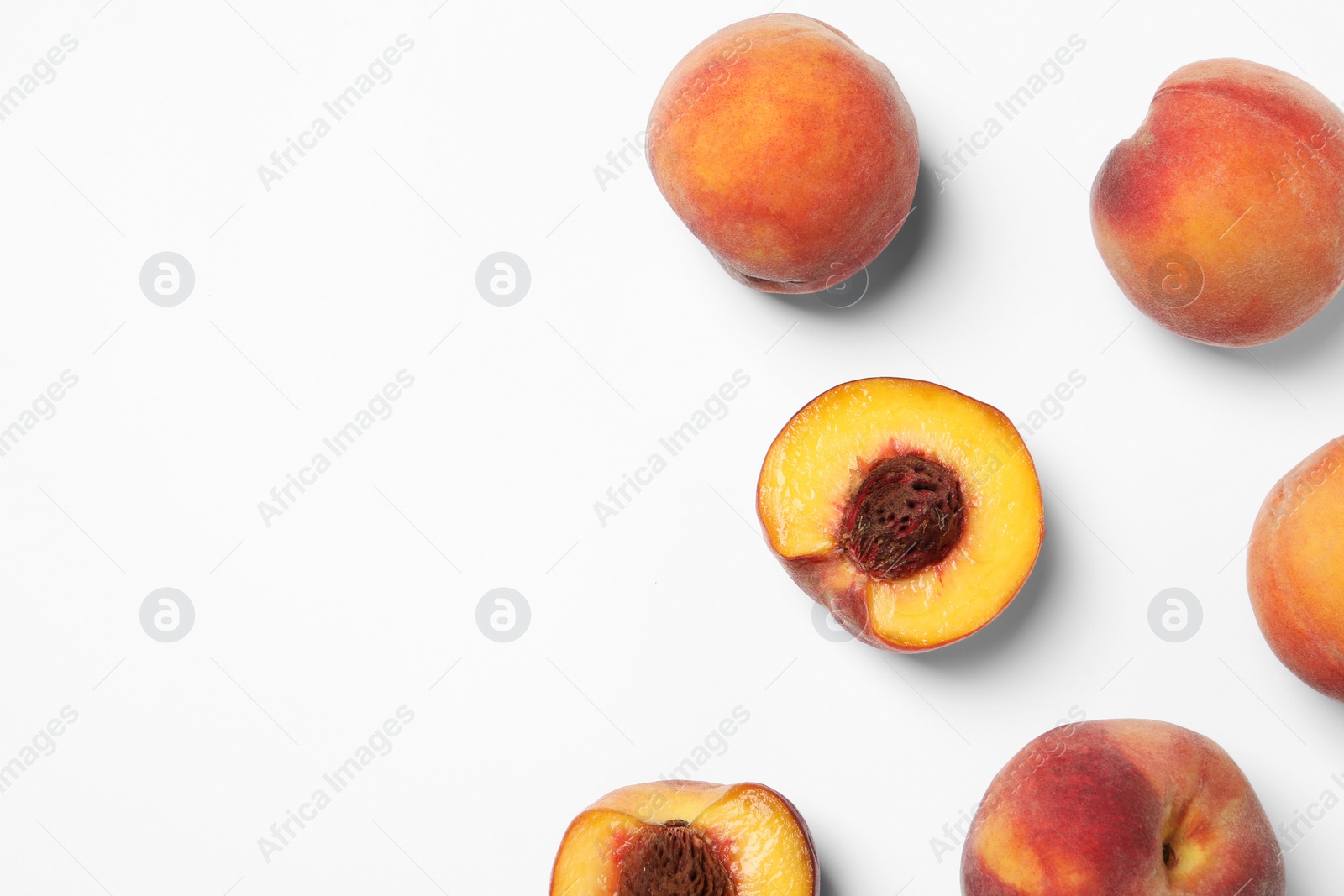 Photo of Cut and whole fresh ripe peaches on white background, flat lay. Space for text