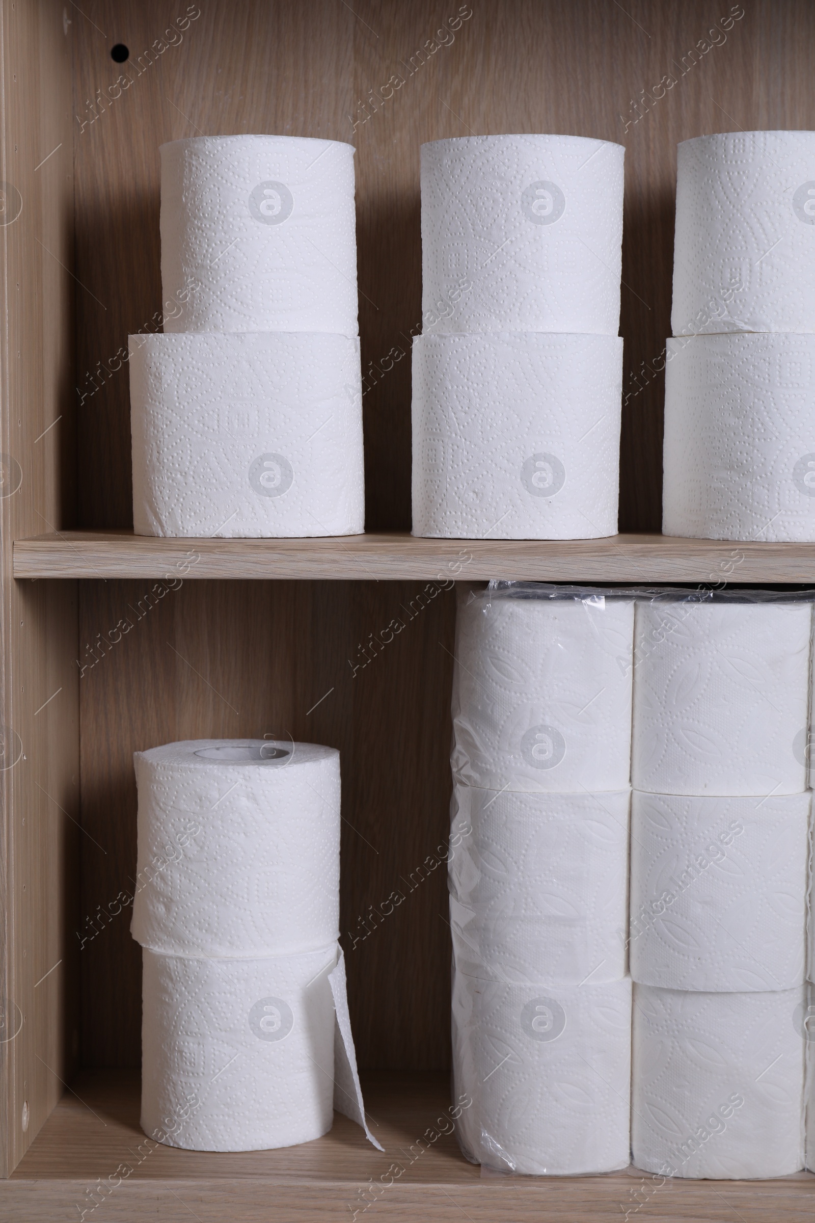 Photo of Stacked toilet paper rolls on wooden shelves