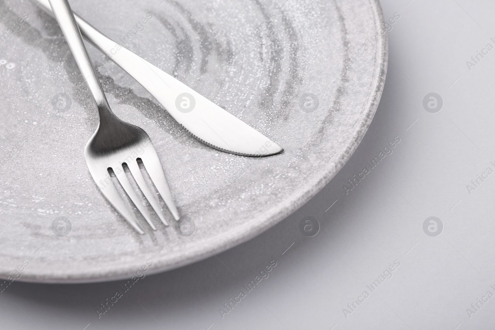 Photo of Setting with stylish cutlery on grey table, closeup. Space for text