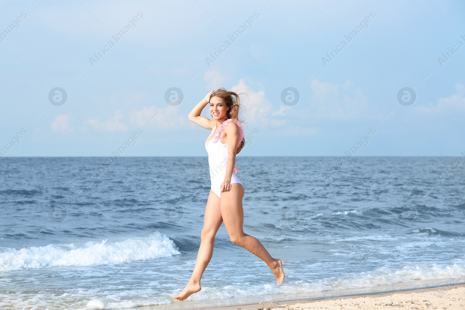 Photo of Attractive young woman in beautiful one-piece swimsuit on beach