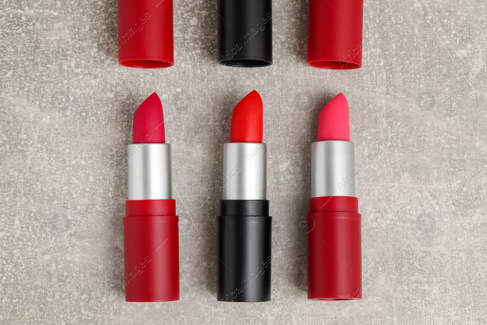 Photo of Different lipsticks on grey table, flat lay