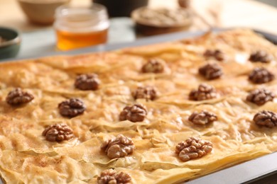 Delicious baklava with walnuts in baking pan on table, closeup