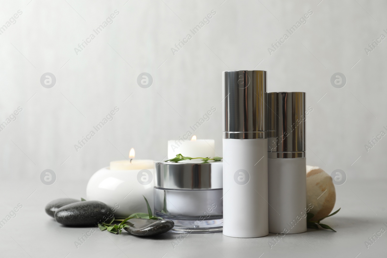 Photo of Composition with cosmetic products on light grey stone table