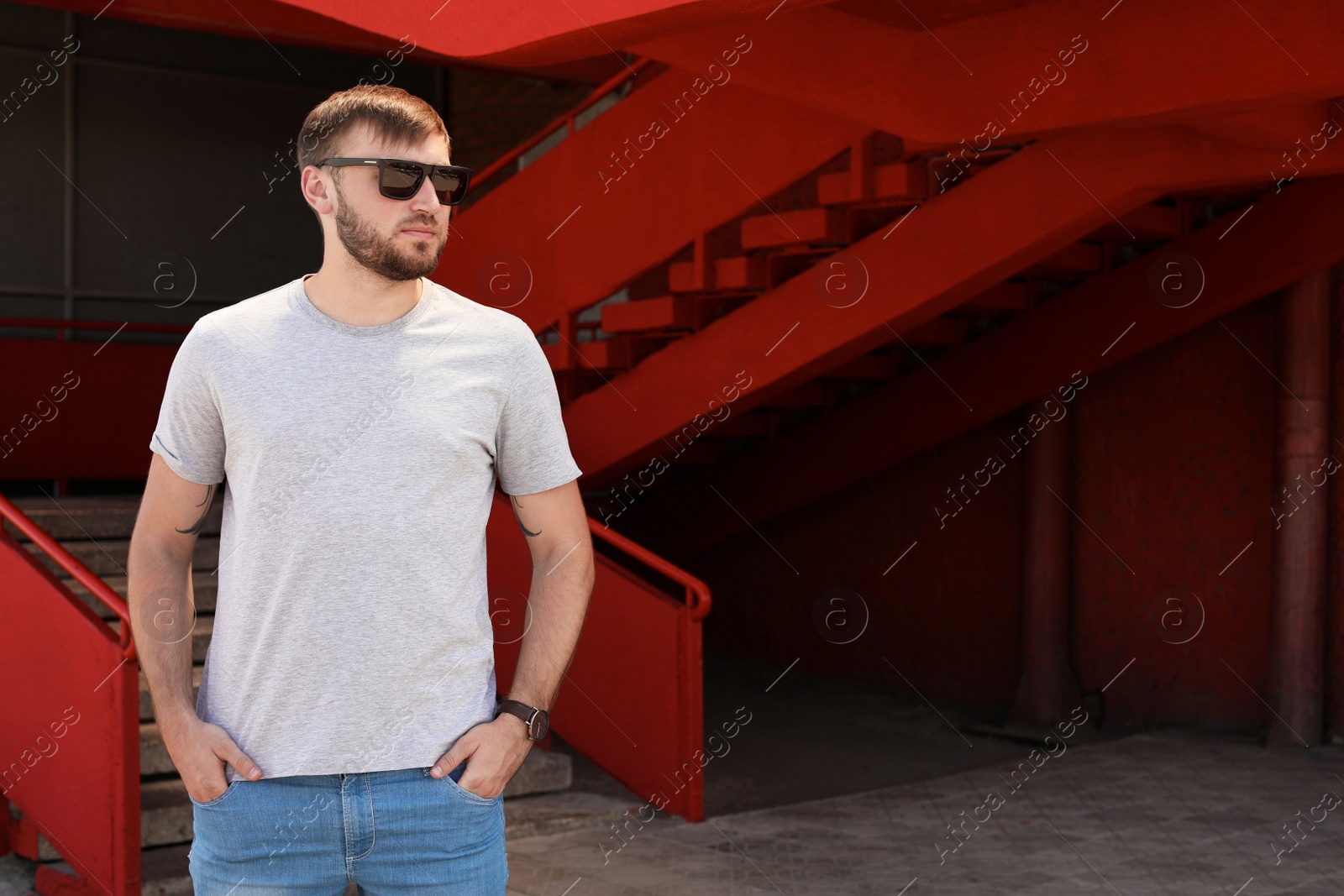 Photo of Young man wearing gray t-shirt on street. Urban style