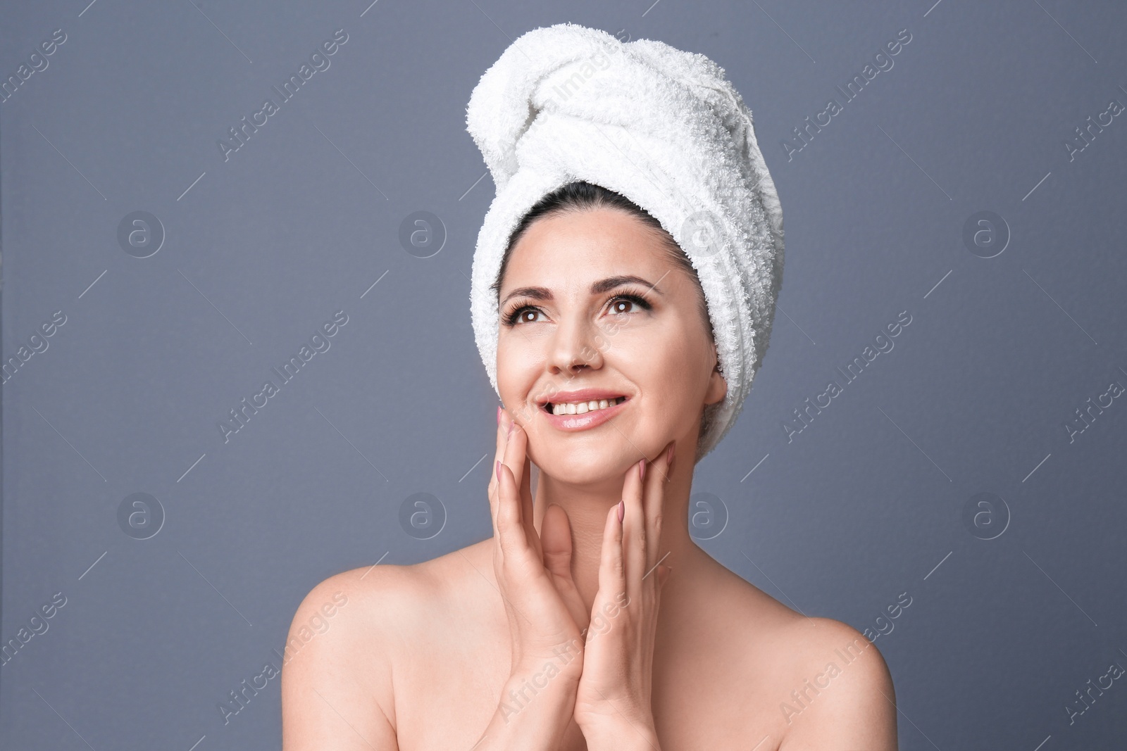 Photo of Beautiful woman with clean skin touching her face on grey background