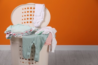 Photo of Laundry basket with baby clothes indoors, space for text