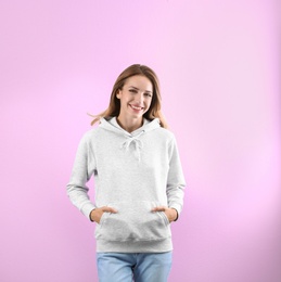 Photo of Portrait of woman in hoodie sweater on color background. Space for design