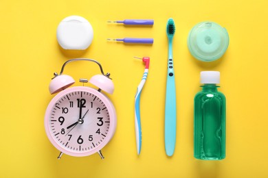 Dental floss, toothbrushes and mouthwash on yellow background, flat lay
