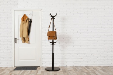 Photo of Hall interior with brick wall and white wooden door