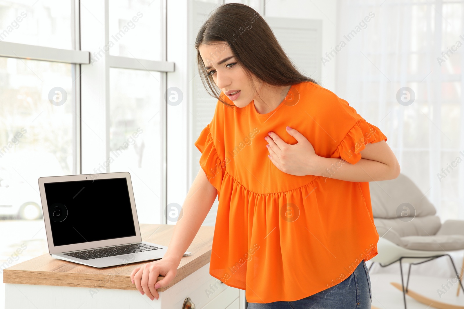 Photo of Young woman suffering from heart attack at home