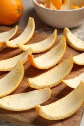 Photo of Many orange peels preparing for drying on grey table, closeup