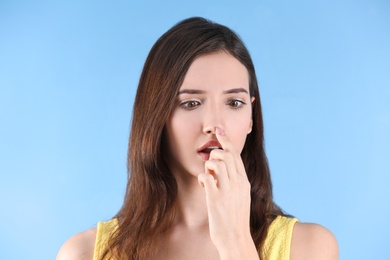 Teenage girl with acne problem against color background