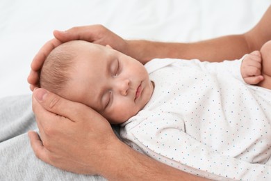 Photo of Father holding his cute sleeping baby, closeup