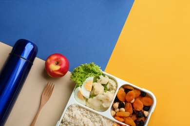 Photo of Thermos and lunch box with food on color background, flat lay. Space for text