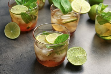 Glasses with mint julep cocktail on grey table